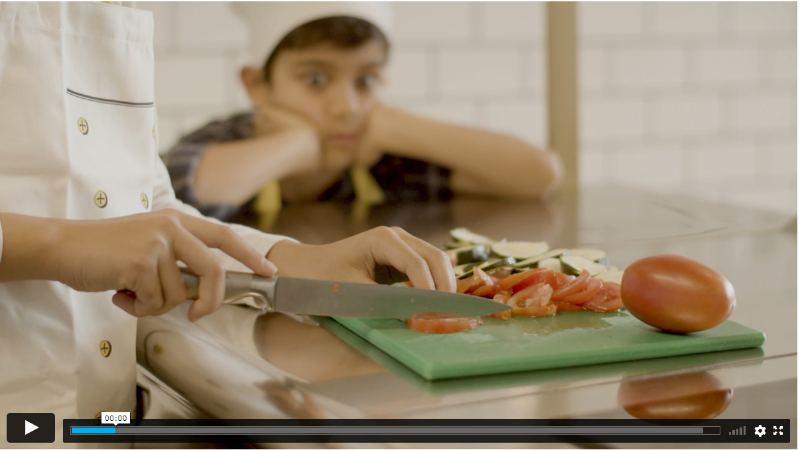 Esta imagen muestra una persona cortando verduras en una tabla