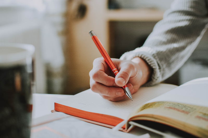 Microrrelato Una persona escribiendo en un cuaderno.