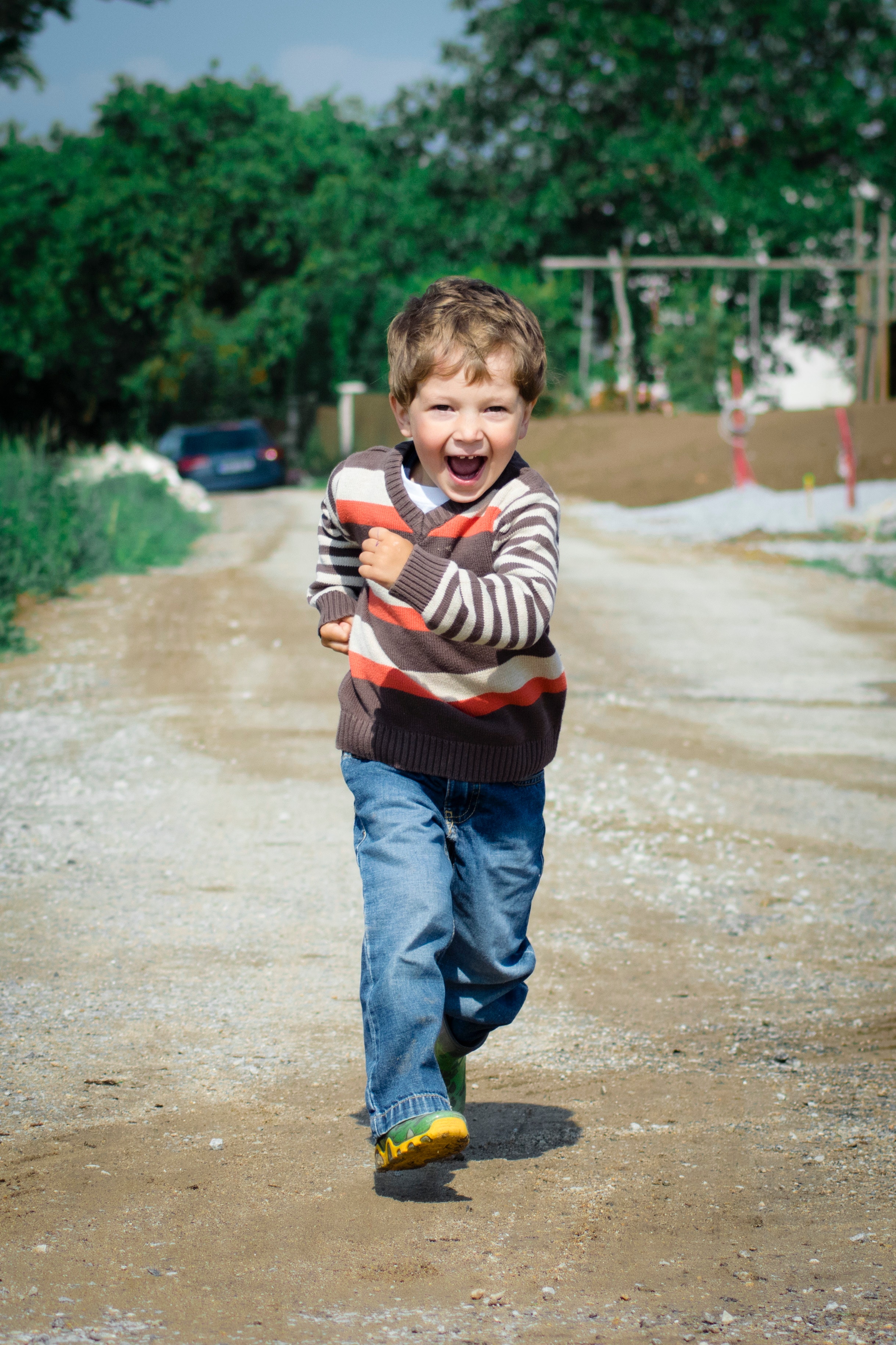 Niño pequeño de unos 4 o 5 años corriendo en un camino y riendo