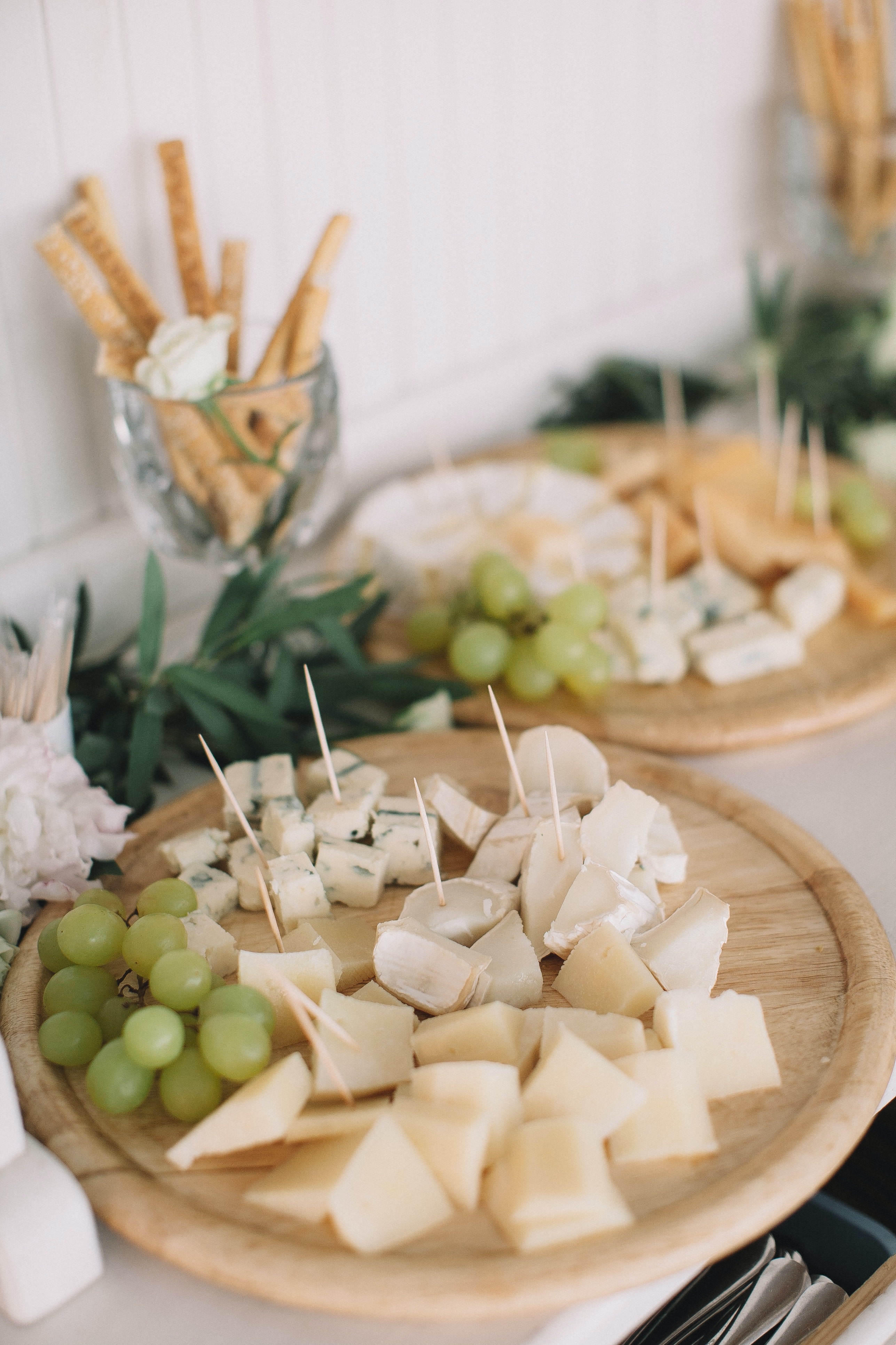 Uvas con queso saben a beso Una tabla de madera llena de uvas y queso cortado en dados y pinchados con palillos de mesa.