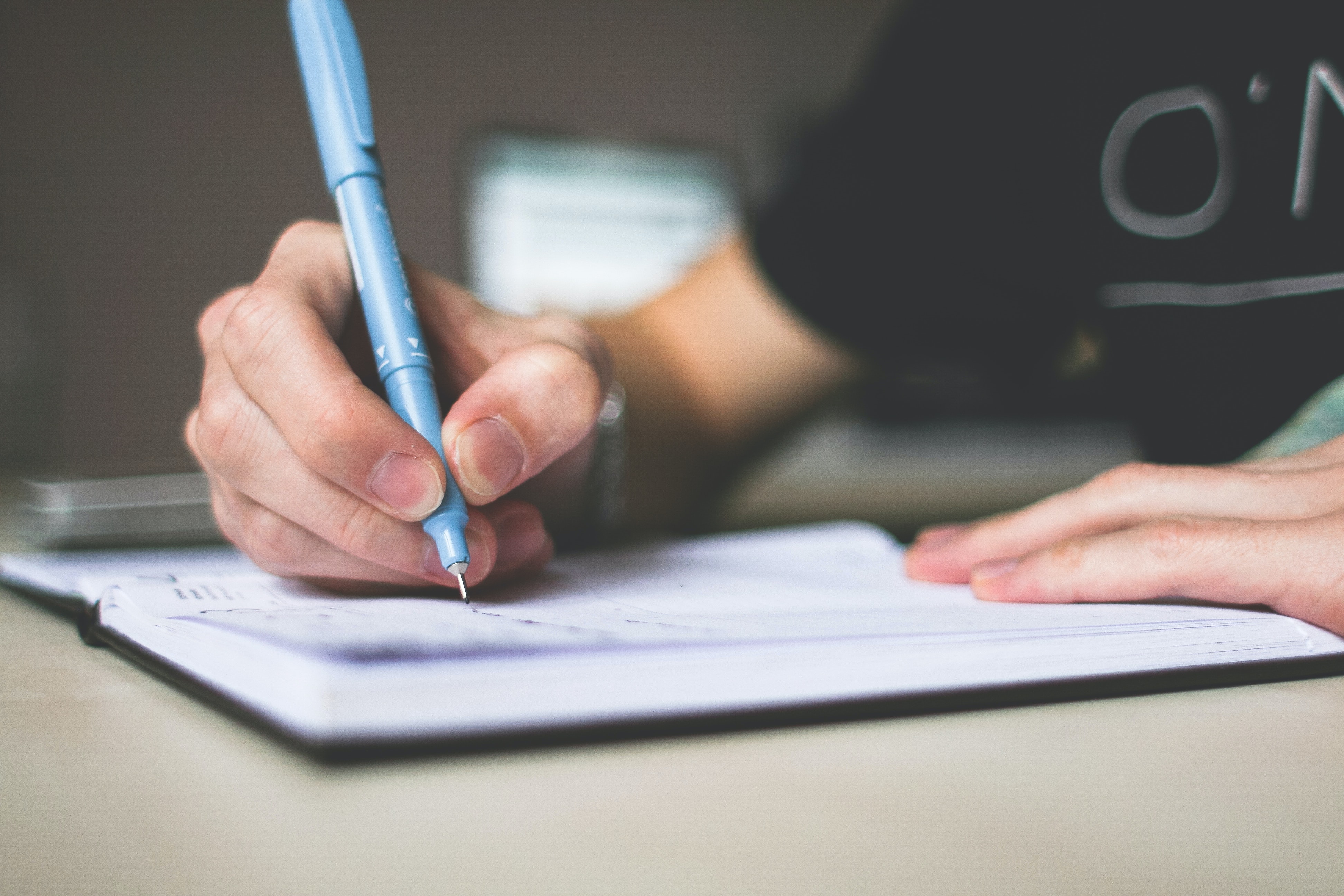 La mano derecha de una niña escribiendo con un bolígrafo
