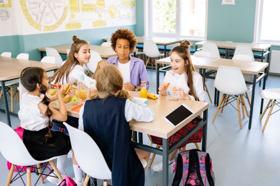 Niños comiendo en un comedor escolar.