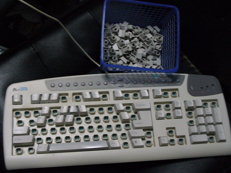 La imagen muestra un teclado sin teclas y las teclas en una cesta
