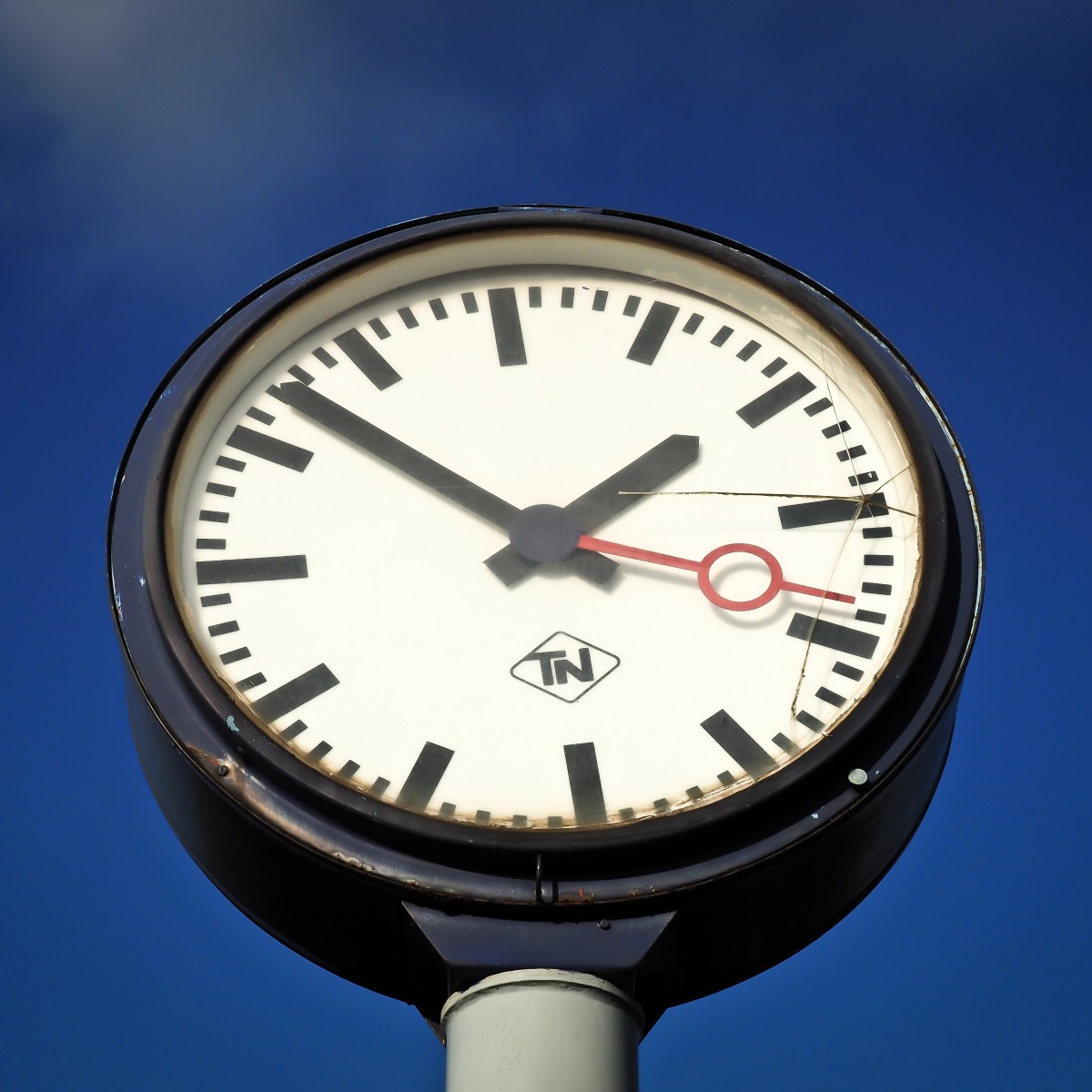 se muestra un reloj grande con las agujas horarias de color negro y el secundero de color rojo