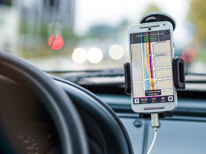 Dispositivos móvil sujeto al parabrisas de un coche mostrando la ruta a un destino