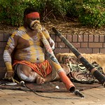 En la imagen puedes ver un nativo australiano tocando un didgeridoo