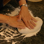 En la imagen puedes ver unas manos de mujer amasando pan
