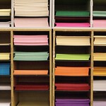 En la imagen puedes ver unas estanterías con paquetes de papeles de muchos colores diferentes