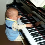 En la imagen puedes ver un bebé tocando un piano de cola