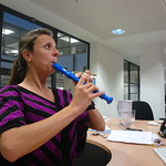 En la imagen puedes ver una mujer tocando una flauta azul