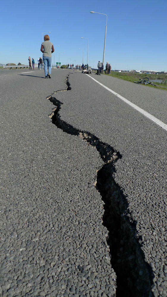 La imagen muestra una carretera partida en dos por una larga y profunda grieta.