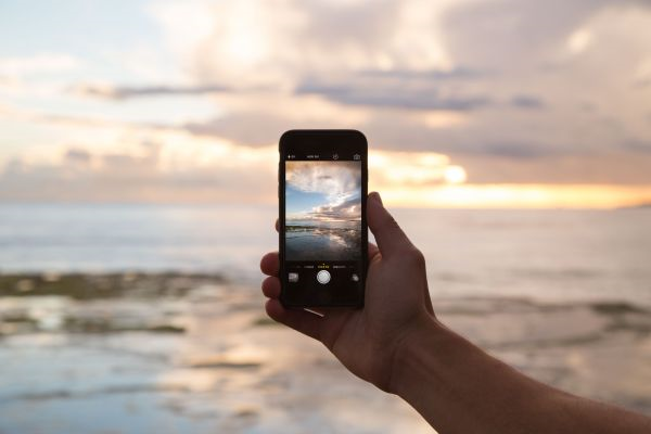 La imagen muestra un teléfono móvil haciendo una foto de paisaje.