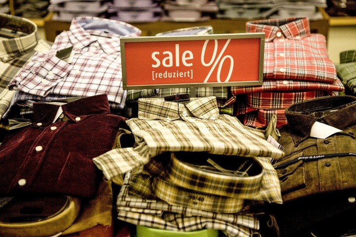 La imagen muestra camisas dobladas en para su venta en una tienda