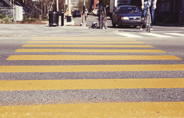 La imagen muestra un paso de cebra en una calle con las líneas pintadas en amarillo.