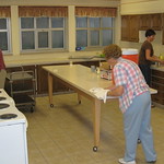 En la imagen puedes ver un grupo de tres personas limpiando una gran cocina