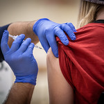 En la imagen puedes ver un enfermero pone una inyección de vacuna a una mujer