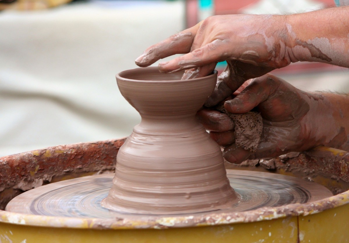 Clay La imagen muestra unas manos moldeando arcilla en un torno.
