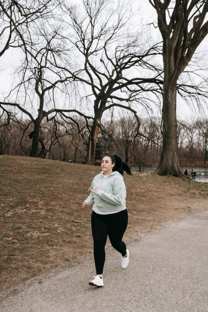 La imagen muestra una persona corriendo por un parque.