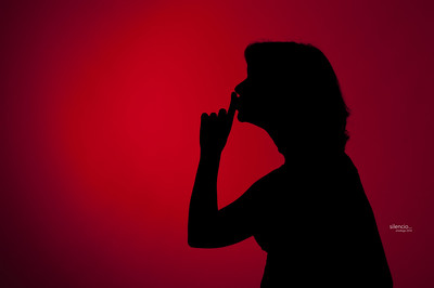 Una mujer pide silencio con el dedo en los labios