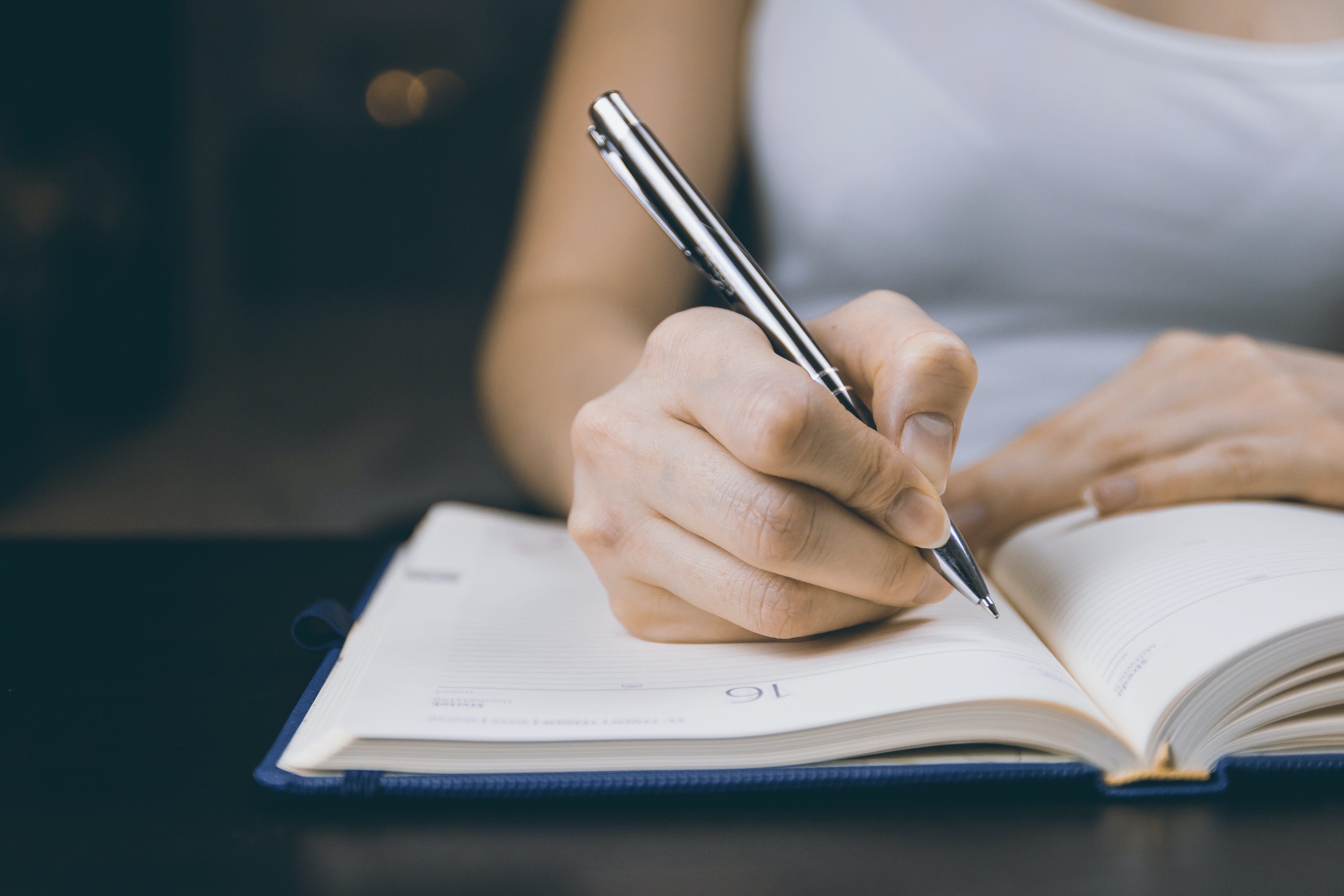 Una persona escribiendo en un cuaderno