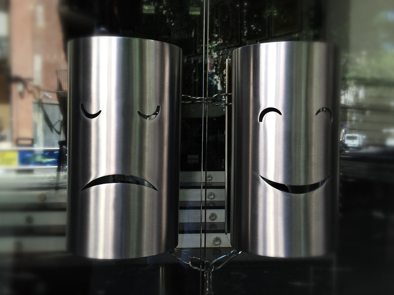 Dos caretas en metal representan la alegría y la tristeza.
