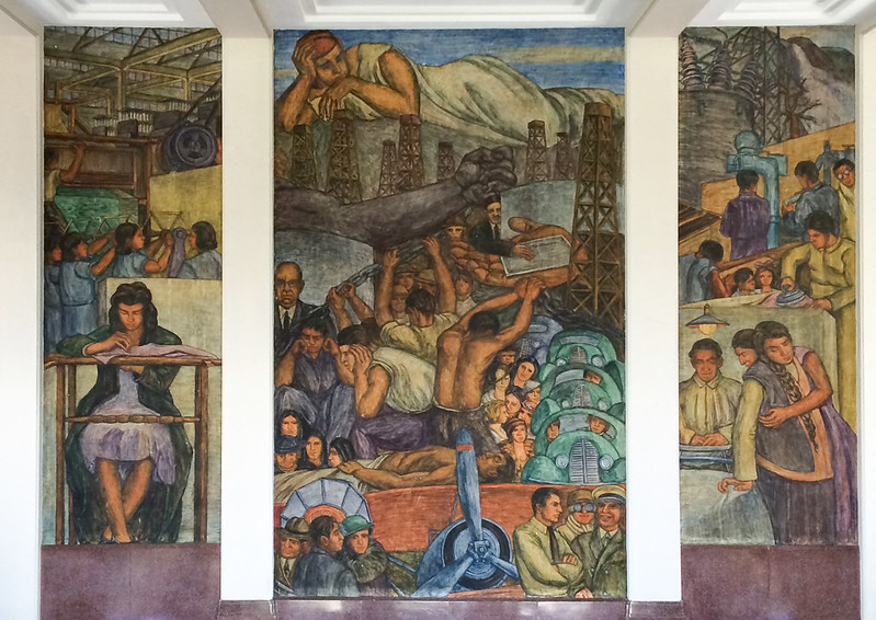 La imagen muestra tres escenas. De izquierda a derecha mural “de la Bordadora a los Telares”, mural “el Problema del Petróleo y la Energía” y el mural “el Trabajo y la Maternidad.
