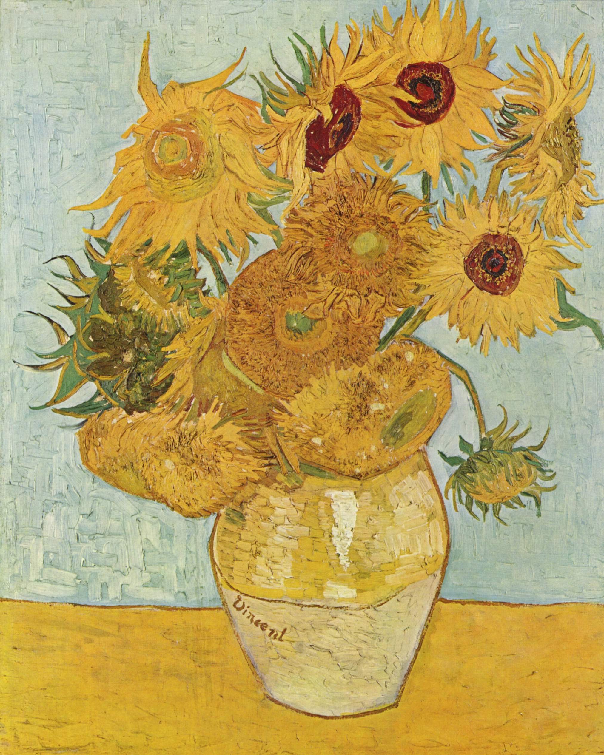 La imagen muestra un jarrón amarillo sobre una mesa y un fondo azul, que tiene varios girasoles amarillos