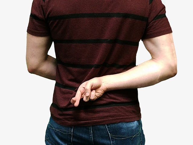 Imagen que muestra una persona cruzando los dedos en su espalda.