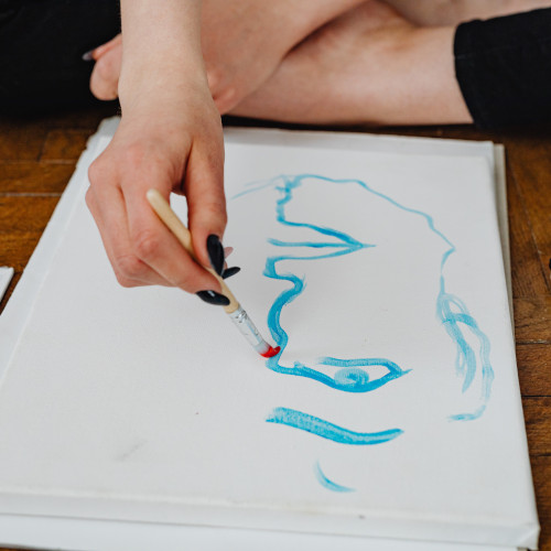 fotografía de un folio blanco con trazos azules hechos con un pincel