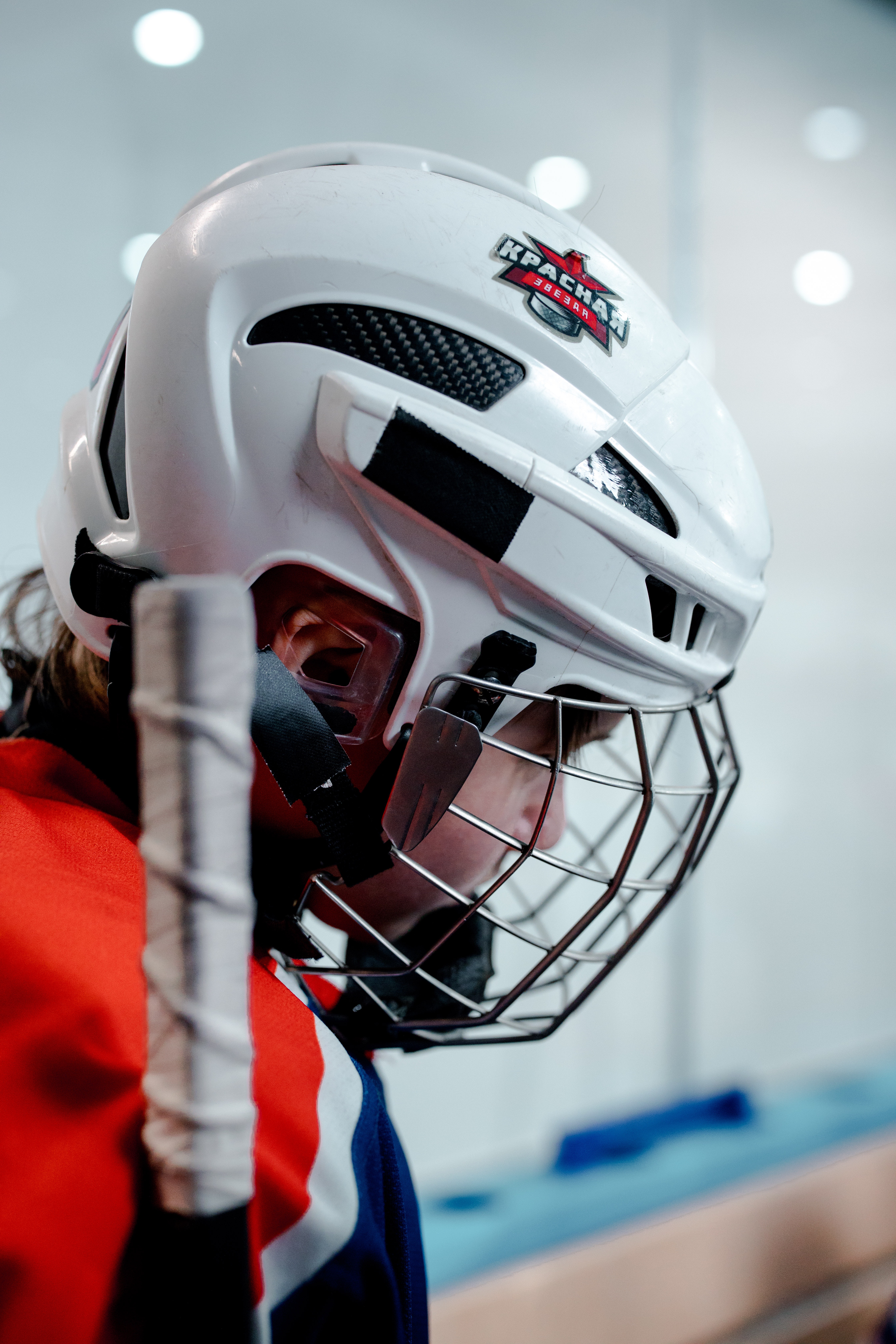 Un niño jugador de hockey con un casco blanco sobre su cabeza
