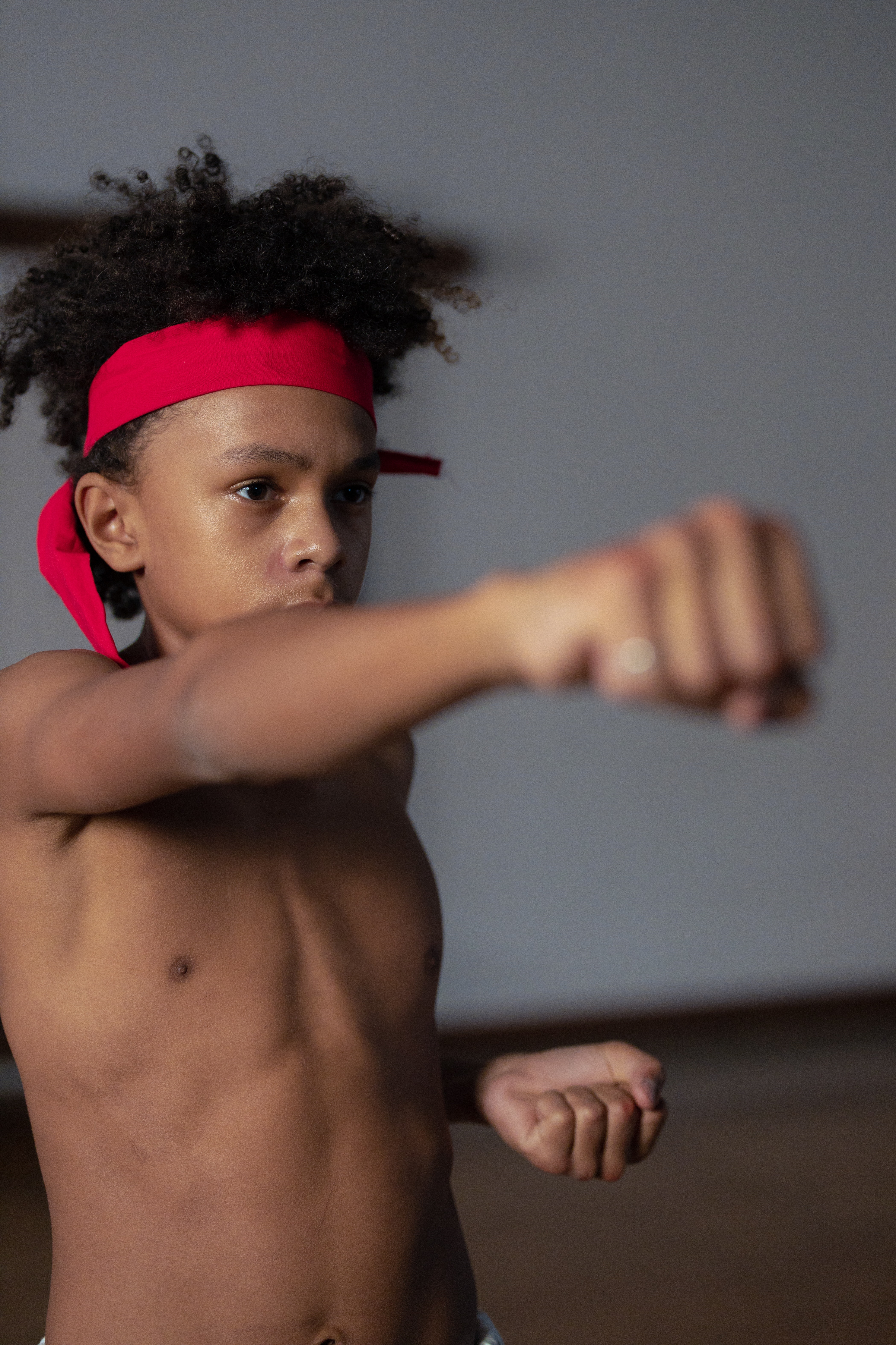Niño practicando karate lanzando un puñetazo al aire.