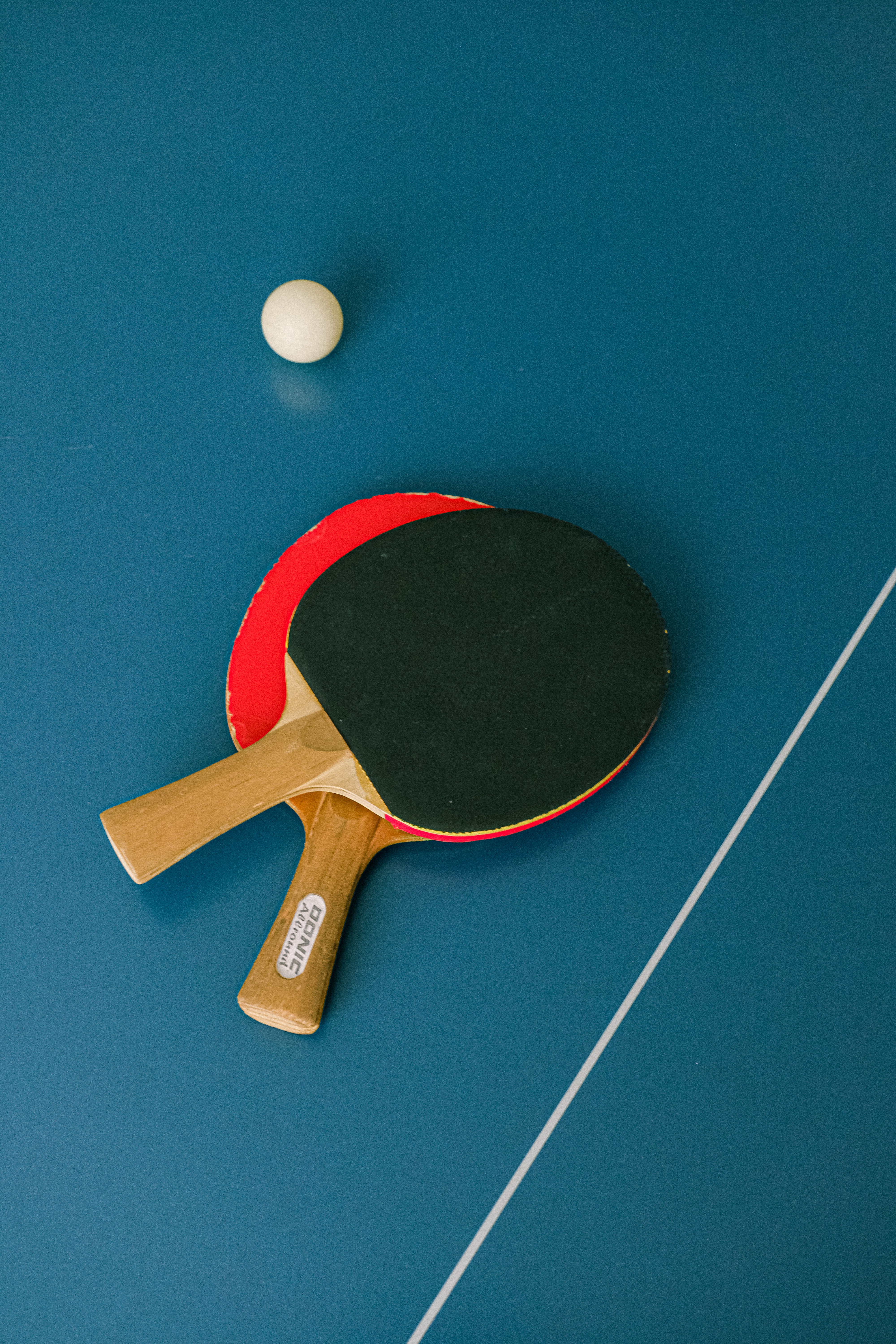 Palas de ping-pong y pelota sobre mesa de ping-pong
