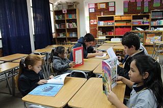 Niños y niñas leyendo en una biblioteca escolar