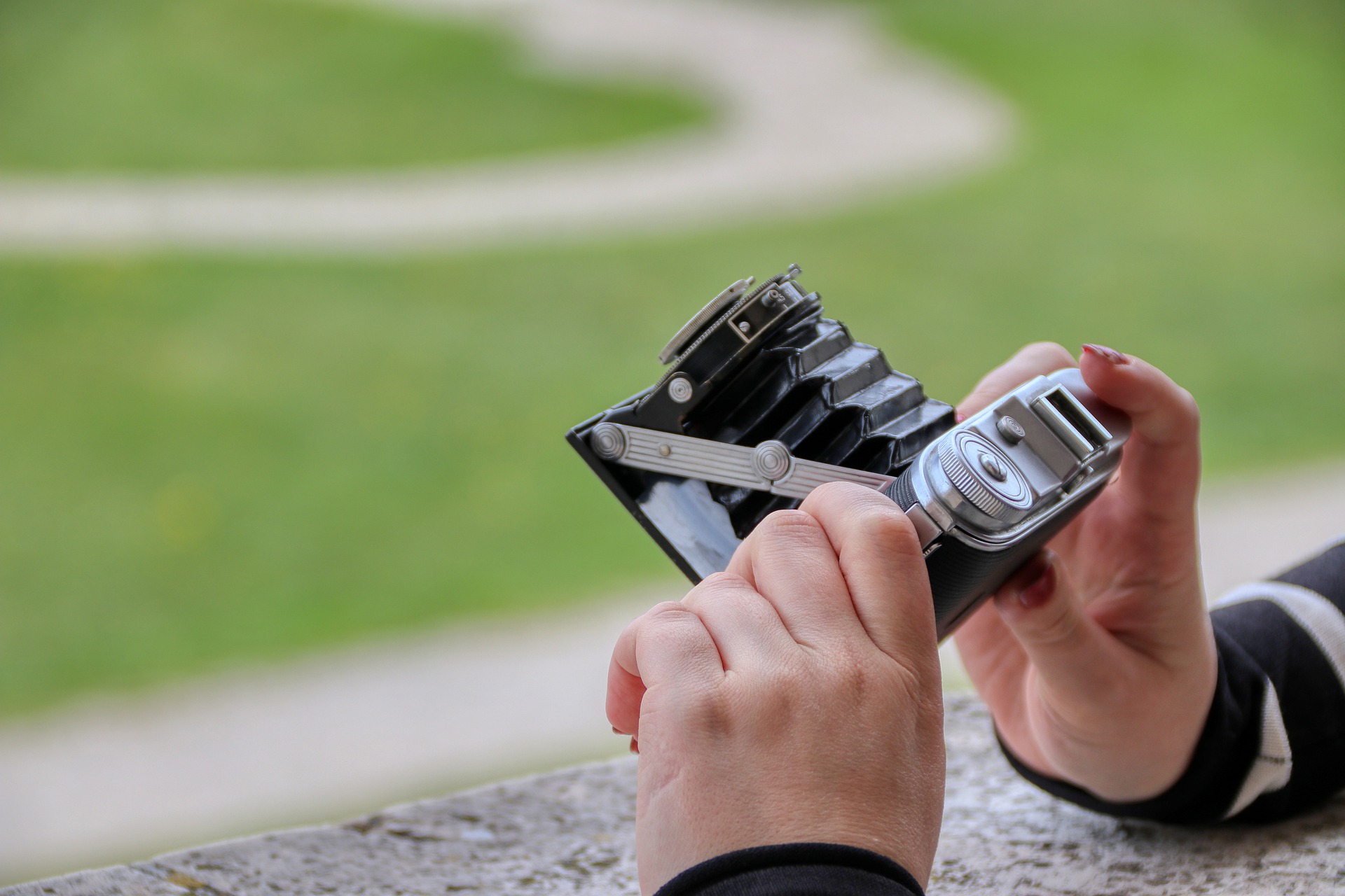 Manos de persona sujetando una cámara de fotos en una posición para realizar un tipo de ángulo.