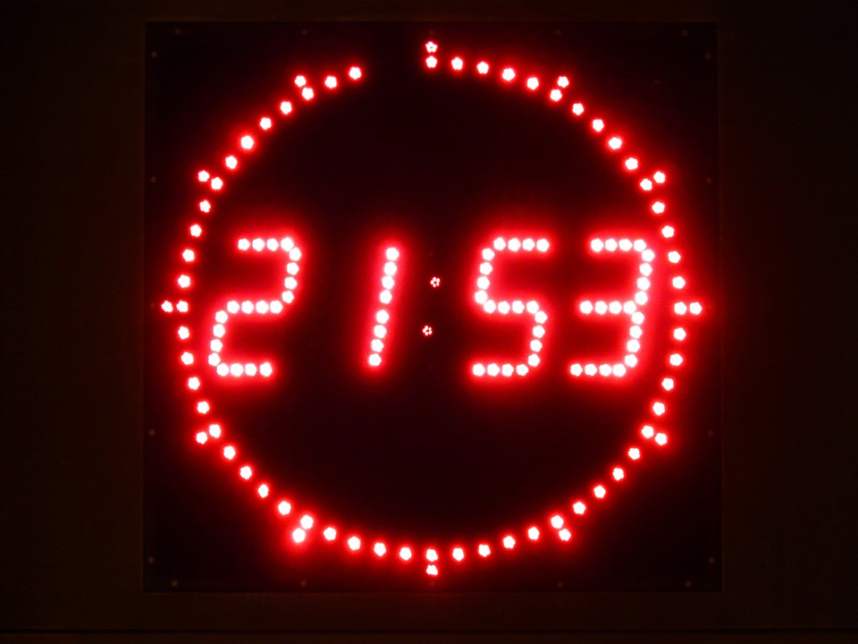 La imagen muestra un reloj digital con los números rojos, y el fondo negro. Marca las 21:53