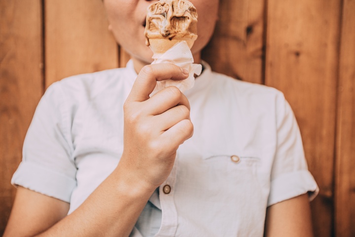 La imagen muestra un niño comiéndose un helado