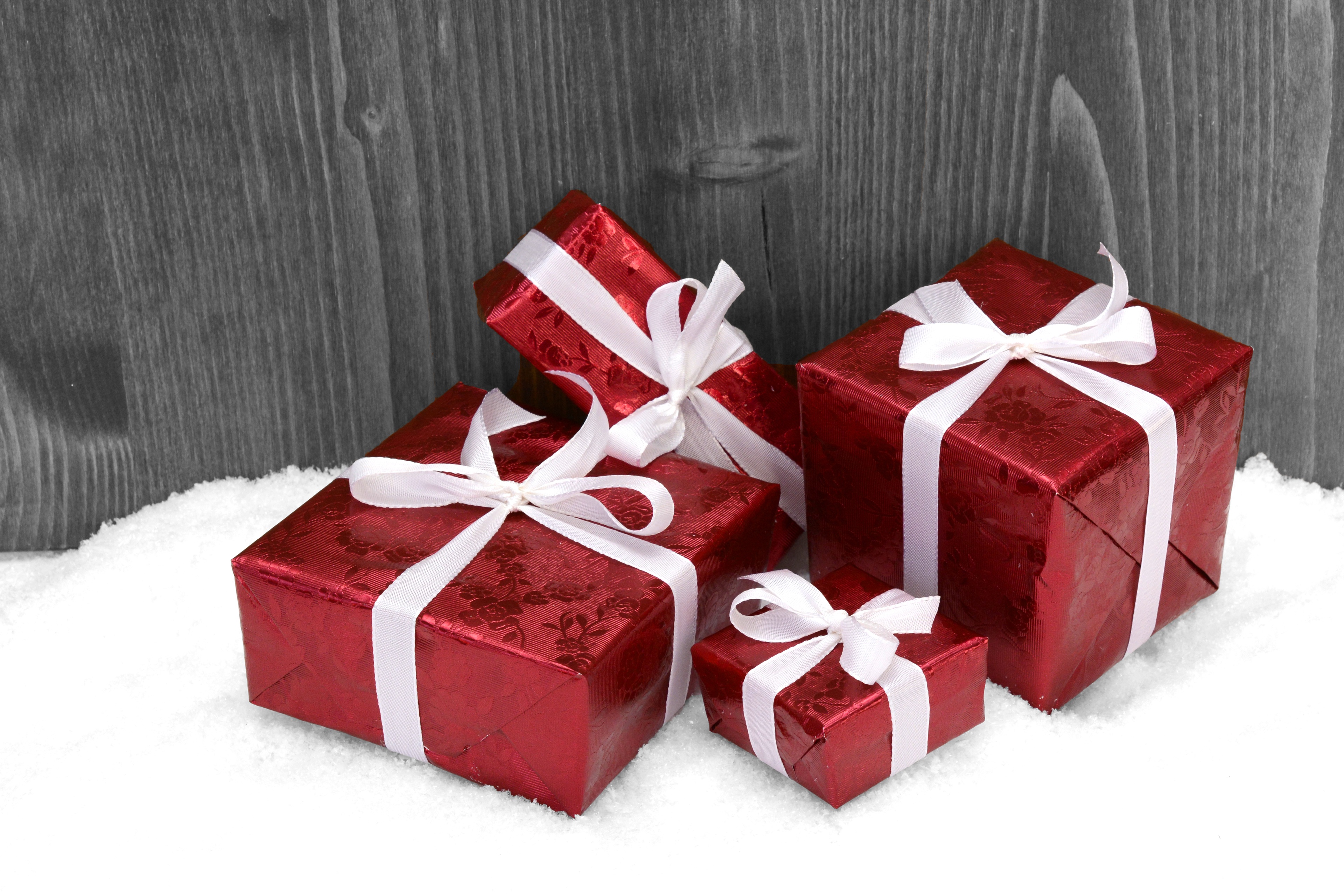 la imagen muestra unos regalos de navidad de color rojo con un lazo blanco