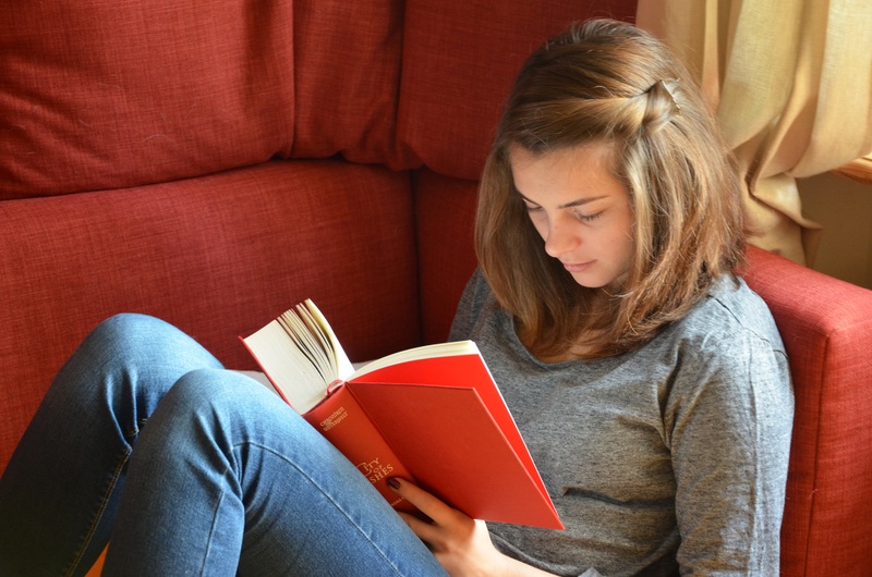 la imagen muestra una adolescentes leyendo un libro