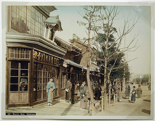  Vista coloreada a mano .Exterior del estudio fotográfico de Kimbei
