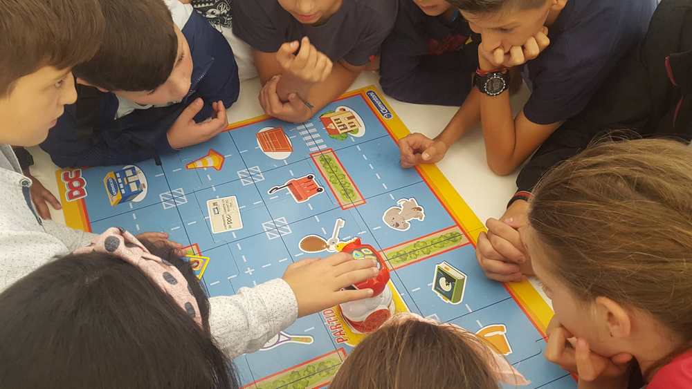 Varios/as niño/as están jugando a un juego de mesa. 