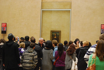 La imagen muestra una muy nutrida cantidad de personas frente al cuadro La Gioconda en el Museo del Louvre.
