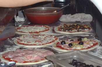 La imagen muestra la preparación de una pizza