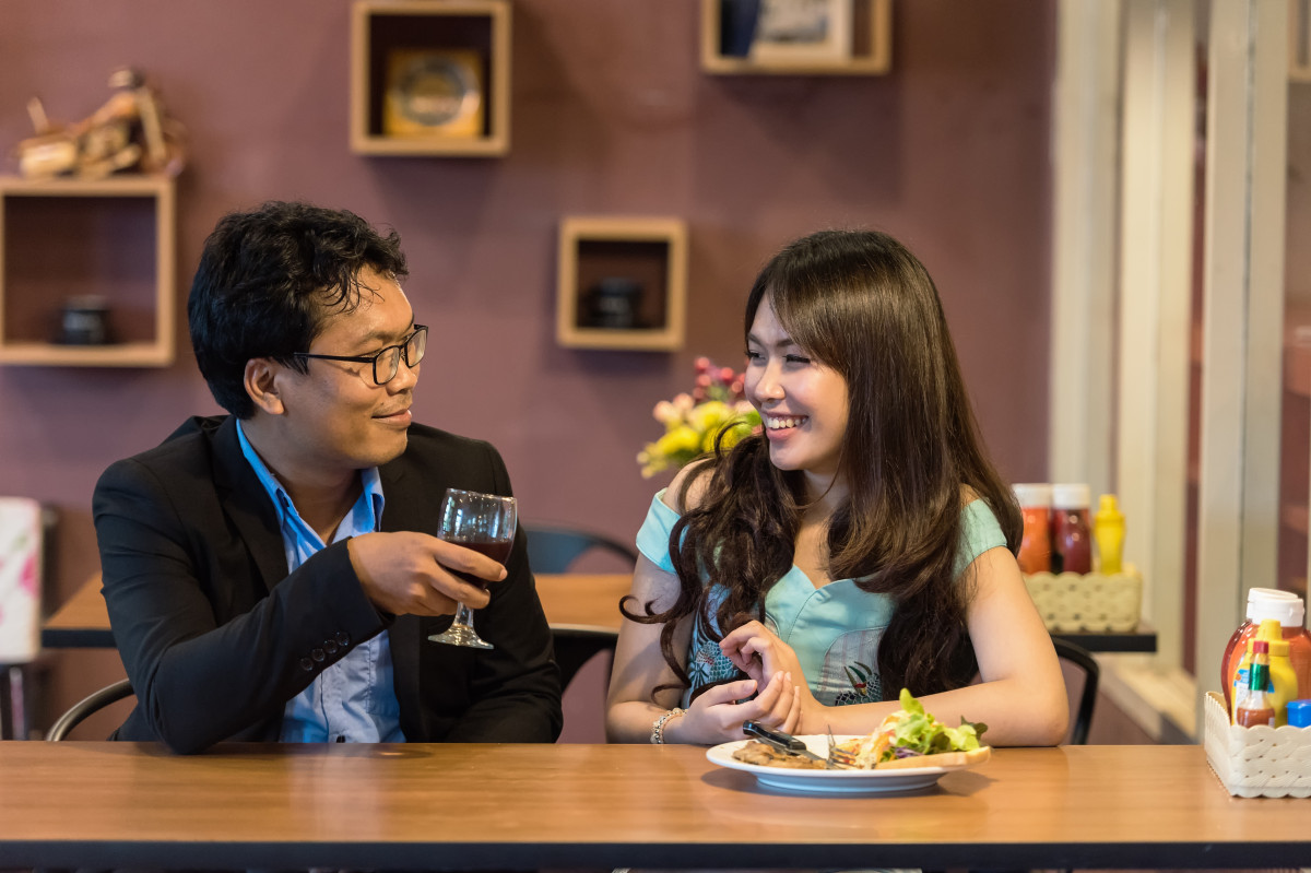 La imagen muestra una pareja comiendo en un restaurante.