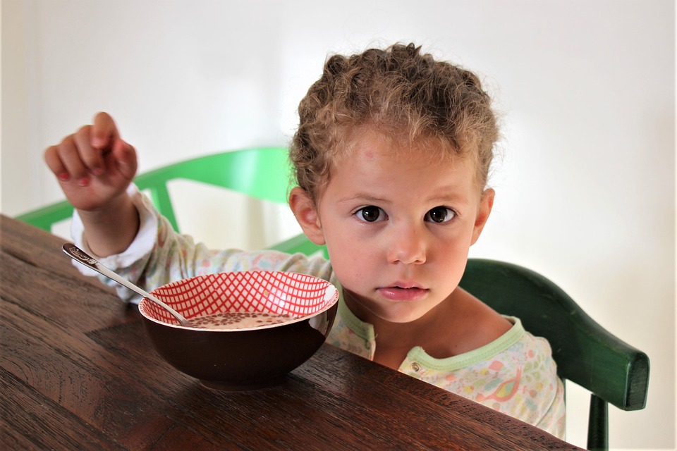 La imagen muestra un niño tomando cereales