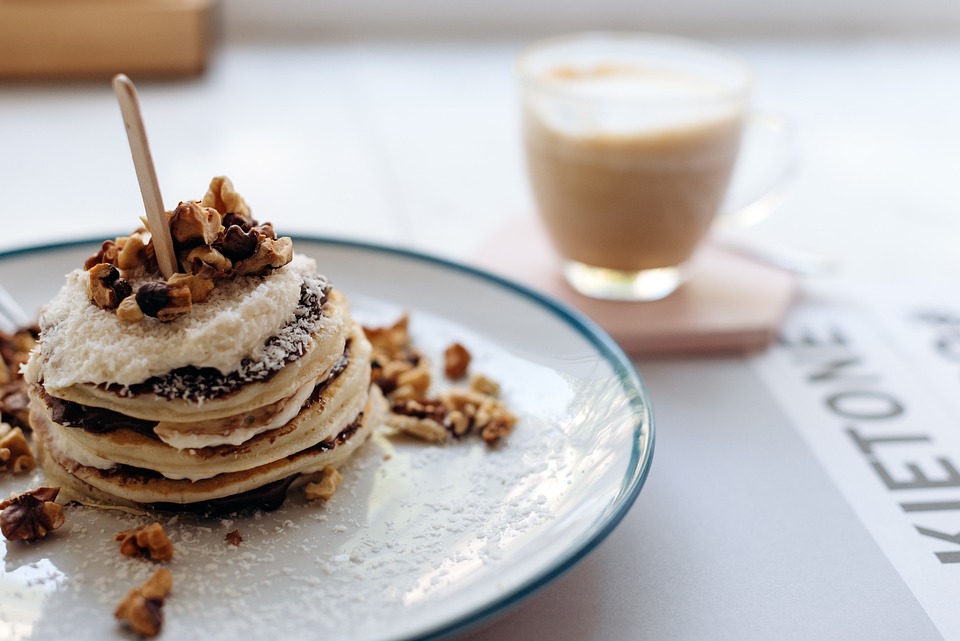 La imagen muestra un pancake y un café