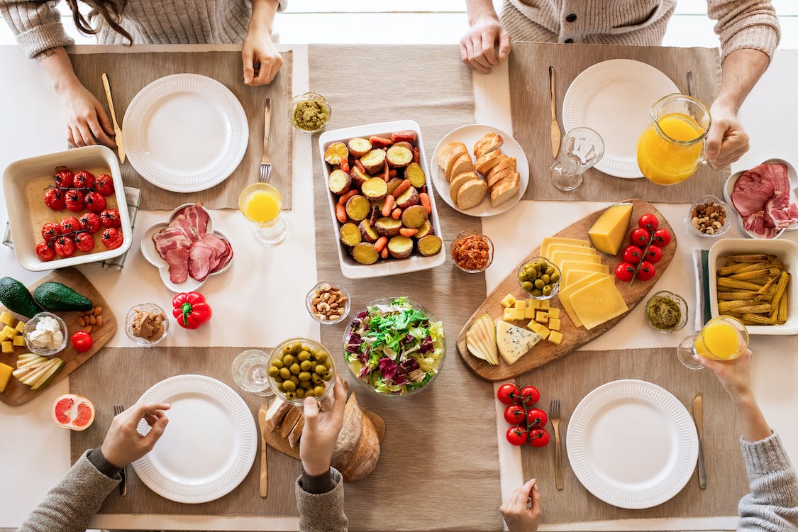 La imagen muestra una mesa con variedad de platos de comida para desayuno.