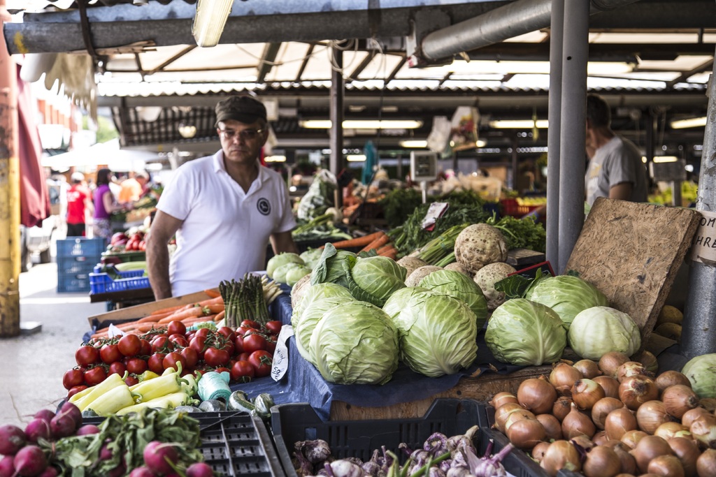 fotografía de un mercado con diferentes puestos de frutas y verduras