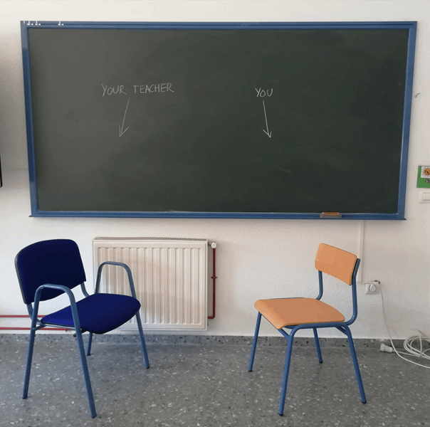 La imagen muestra una silla del profesorado y una silla del alumnado junto a una pizarra. 