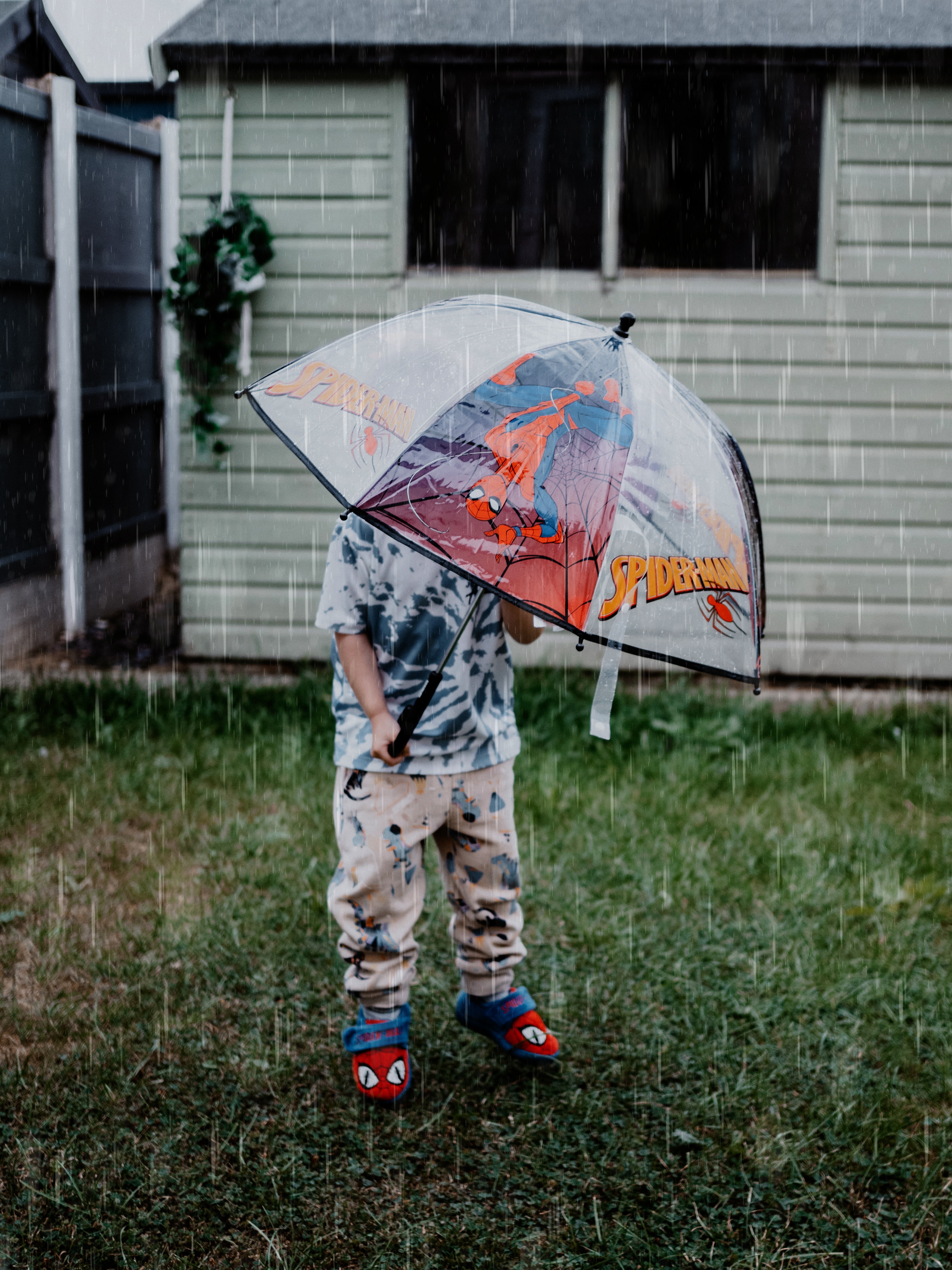 Foto de un niño con paraguas con lluvia.