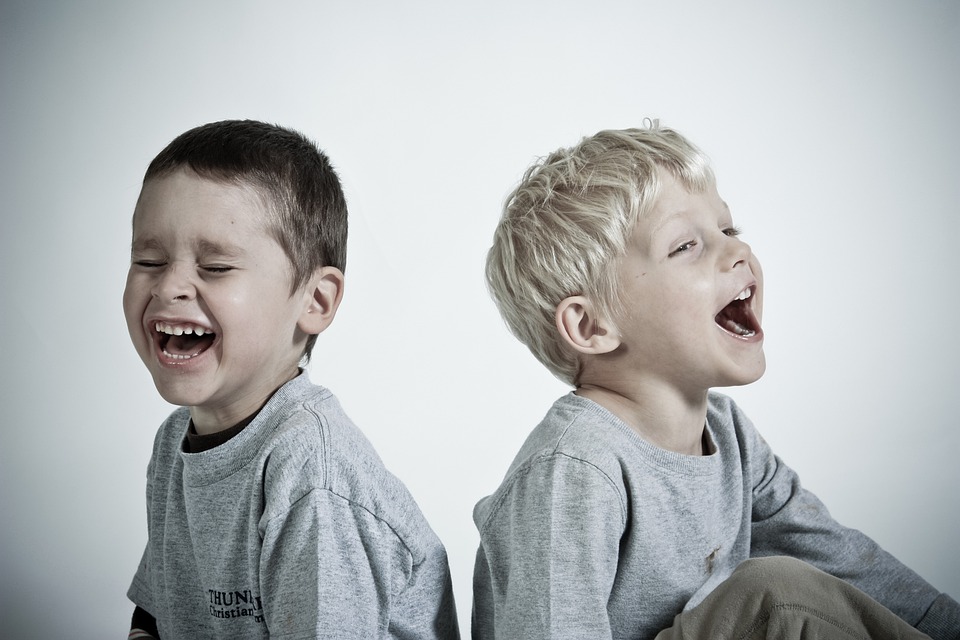 La imagen muestra dos niños expresando la emoción contento
